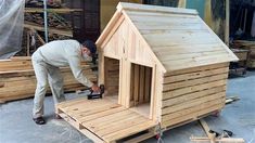 a man is building a dog house out of pallet wood and plywood planks