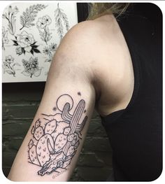 a woman's arm with a tattoo on it that has a cactus and moon