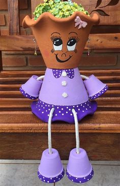 a potted planter sitting on top of a bench with purple shoes hanging from it