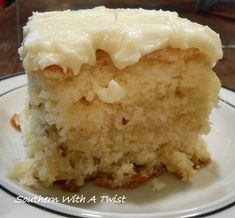 a close up of a piece of cake on a plate with frosting and nuts