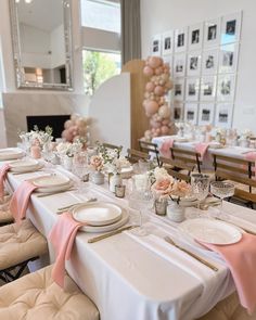 a long table with white plates and pink napkins