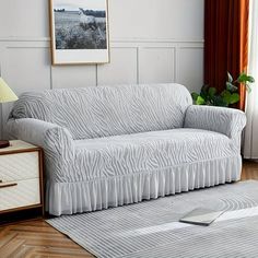 a living room with a couch, rug and lamp on the side table in front of it