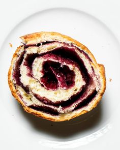 a white plate topped with a pastry covered in jelly