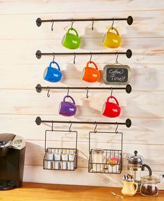 a coffee maker and cups are hanging on the wall