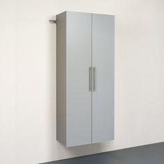 a tall white cabinet sitting next to a wall