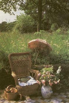 a wicker chair sitting on top of a checkered floor next to a basket filled with flowers