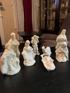 some white figurines sitting on top of a black table in a living room