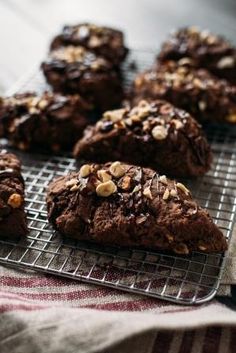 chocolate cookies cooling on a wire rack with some nuts in the middle and one half eaten