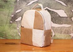 a brown and white backpack sitting on top of a wooden table