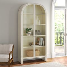 a white bookcase with glass doors in a living room