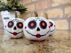 two painted pumpkins sitting on top of a counter