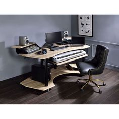 a computer desk with a keyboard, mouse and monitor on it in front of a gray wall