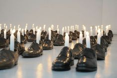 several pairs of shoes are lined up with candles