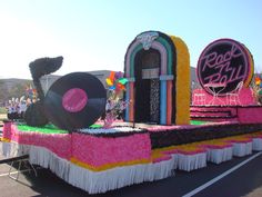 the float is decorated in pink, yellow and black colors with an old record on it