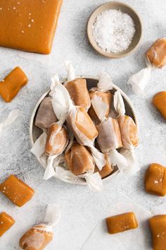 small bowls filled with different types of food on top of a white countertop next to salt and butter cubes