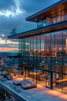 a large glass building with lots of windows on top of it at sunset or dawn