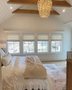 a large bed sitting under two windows in a bedroom