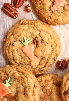 several cookies with candy on top and pecans in the background, all decorated to look like carrots