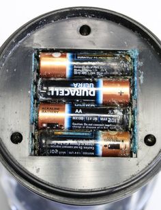 three batteries in a metal container sitting on top of a table