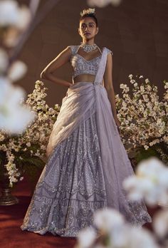 a woman standing in front of flowers wearing a dress