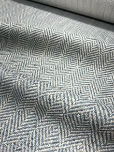 a close up view of a blue and white rug with herringbones on it