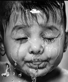 a young boy with his face covered in water