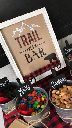 three buckets filled with candy sitting next to a sign that says trail mix bar