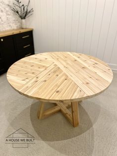 a round wooden table sitting on top of a carpeted floor