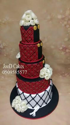 a red and black wedding cake with white flowers