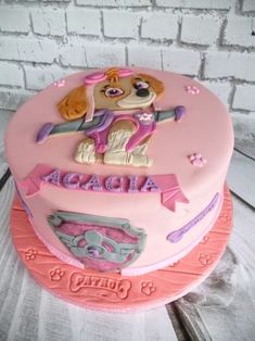 a pink birthday cake with a dog on top