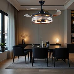 a dining room table with black chairs and a chandelier hanging from the ceiling