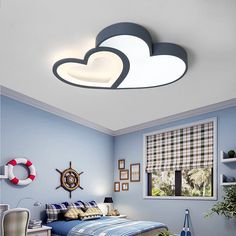 a bedroom with blue walls and white clouds above the bed