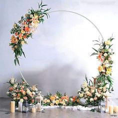 an arch decorated with flowers and candles for a wedding or special event in orange, yellow and white colors