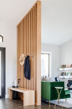 a living room with wooden slats on the wall and a green chair next to it