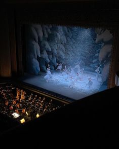 a group of ballet dancers on stage in front of a large screen with lights behind them