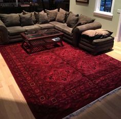 a living room filled with furniture and a red rug