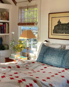 a bed sitting in a bedroom next to a window with a lamp on top of it