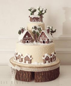 a three tiered cake decorated with white frosting and brown icing houses on top