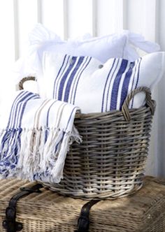 a wicker basket filled with white and blue towels