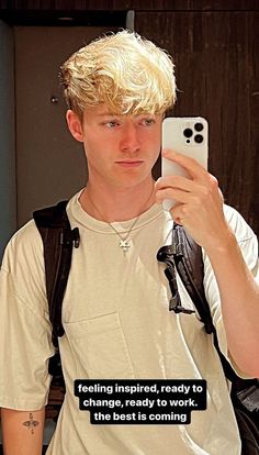 a young man taking a selfie with his cell phone while wearing a white t - shirt