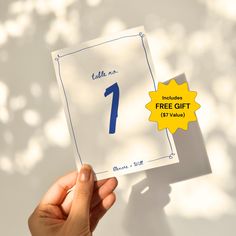 a person holding up a piece of paper with the number one on it, in front of a white background