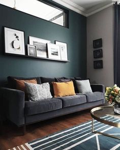 a living room filled with furniture and framed pictures on the wall above a coffee table