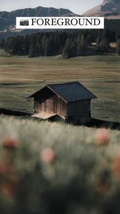 an old barn in the middle of a field with mountains in the background and text overlay that reads foreground