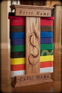 a wooden sign with a horse on it in front of many colored belts that are stacked together