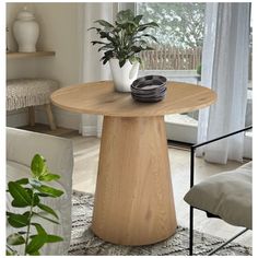 a table with a plant on it in front of a window