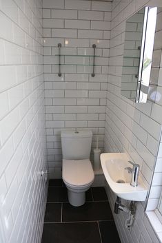 a white toilet sitting in a bathroom next to a sink