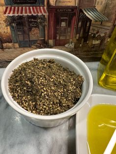 a white bowl filled with green liquid next to a box of oil