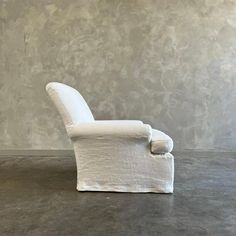 a white chair sitting on top of a cement floor