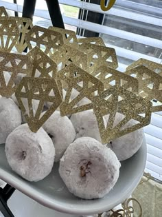 some donuts are on a white plate with gold decorations