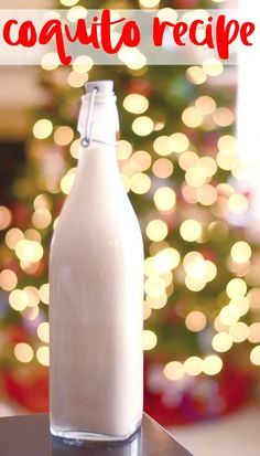 a bottle of coconut oil sitting on top of a table next to a christmas tree